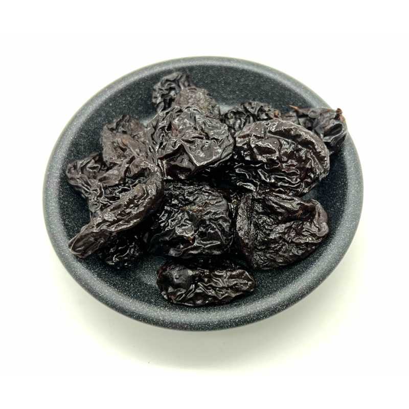 Pitted prunes in a dark bowl