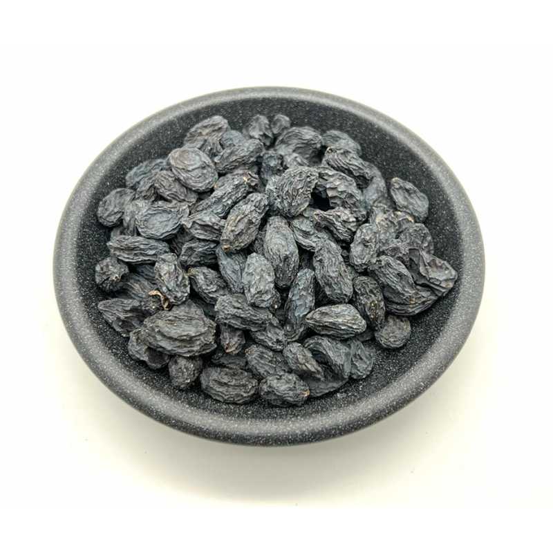 Black raisins in a dark bowl