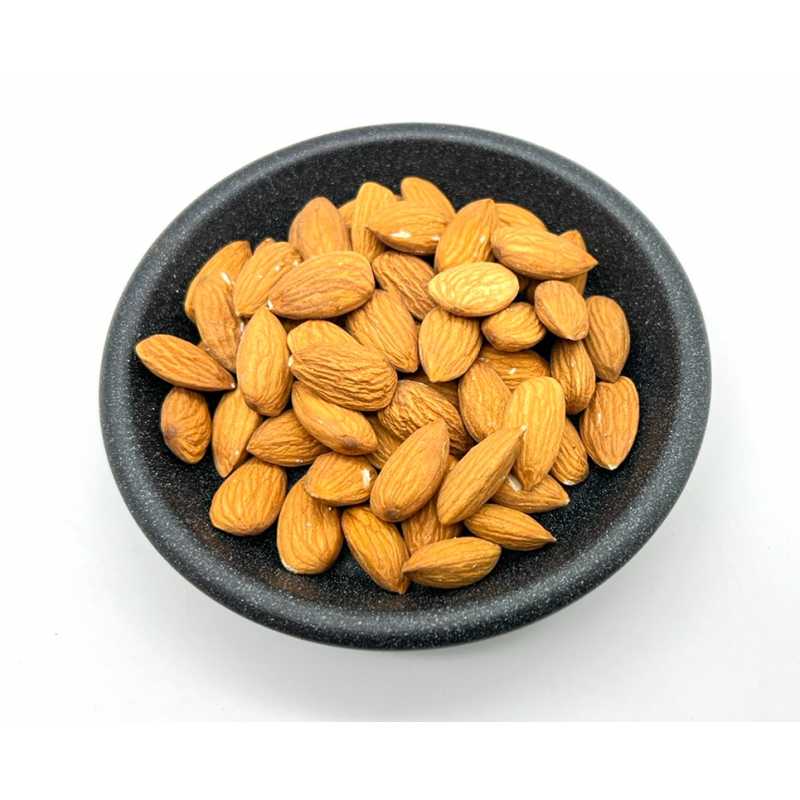 Whole raw almonds in a dark bowl
