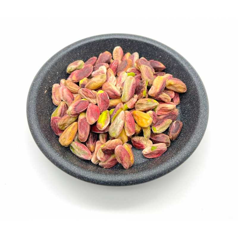 Shelled pistachio kernels in a dark bowl